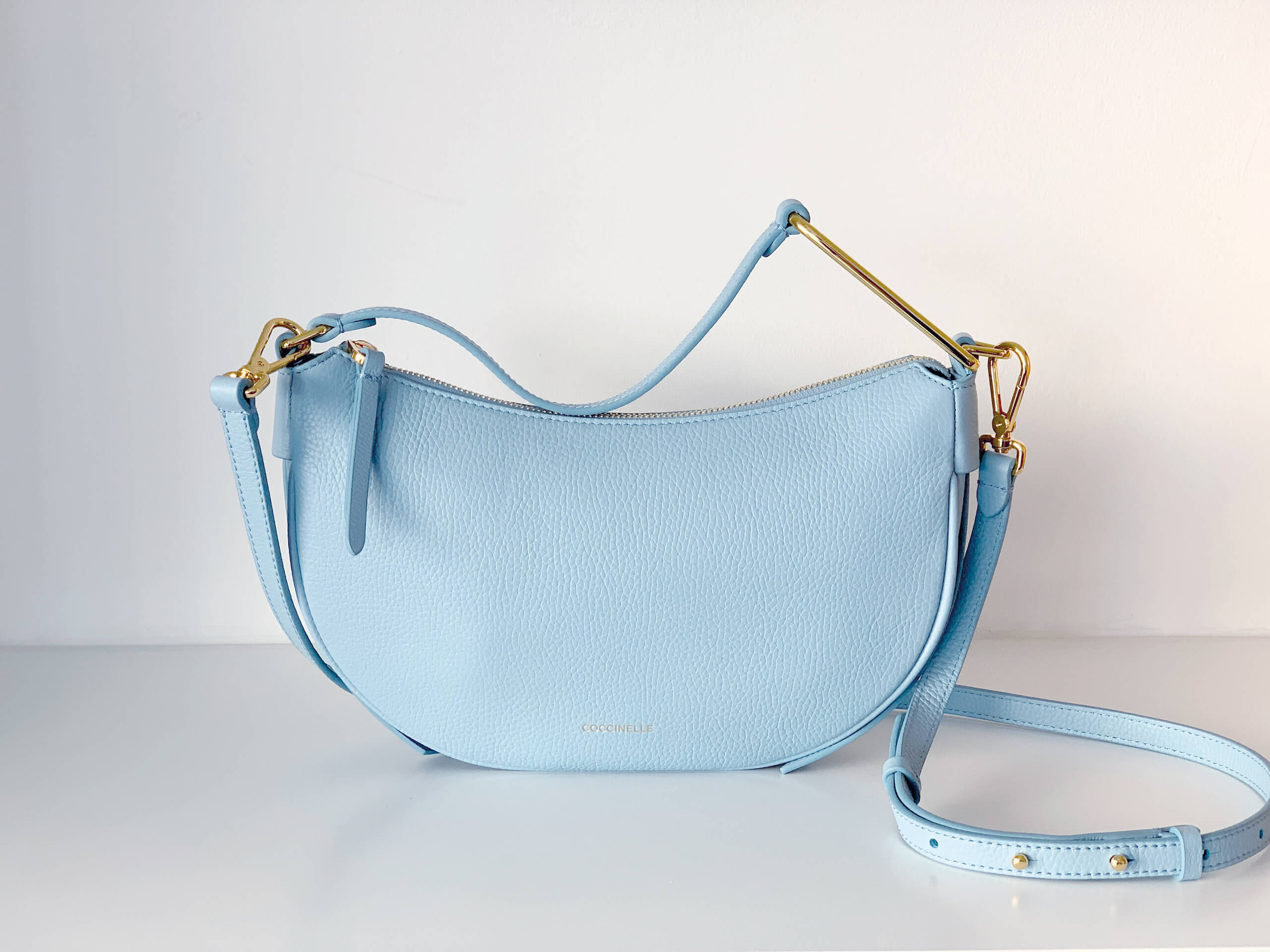 Eine Babyblaue Handtasche mit goldenen Elementen